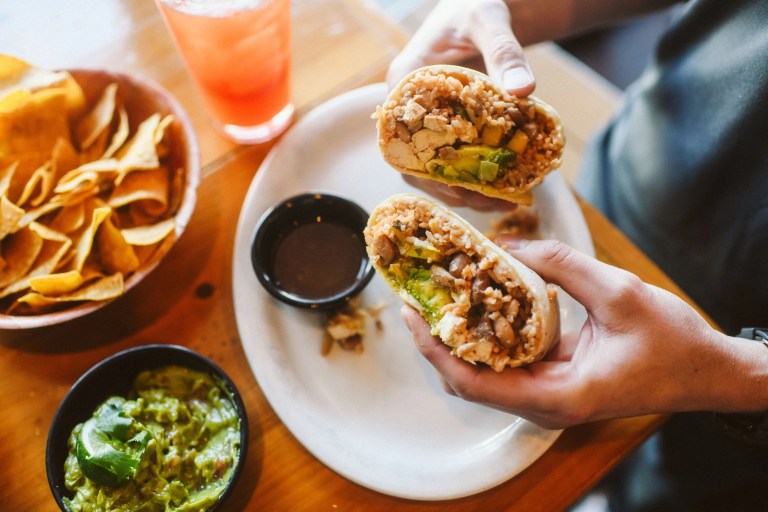 HandHoldingBurritooverPlate 768x512