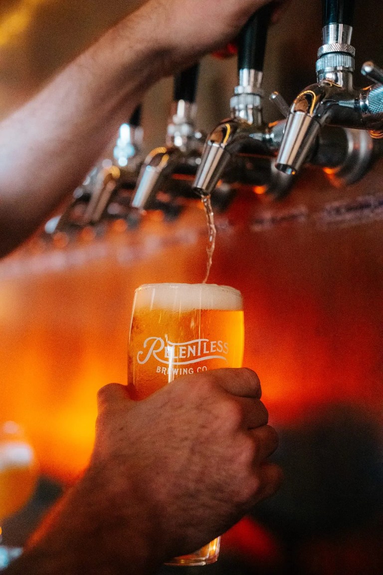 relentless brewing co pouring craft beer from tap 768x1152